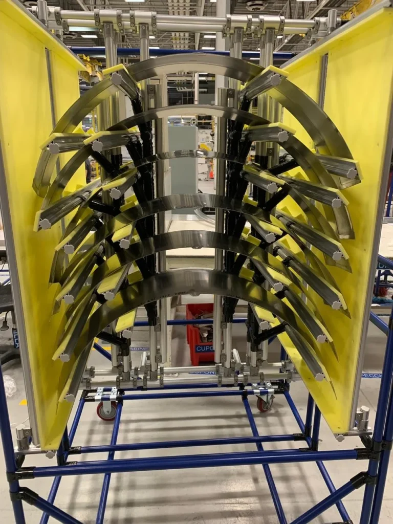 Rack industrial con paneles Durawood protegiendo componentes metálicos curvos en planta de producción aeronáutica