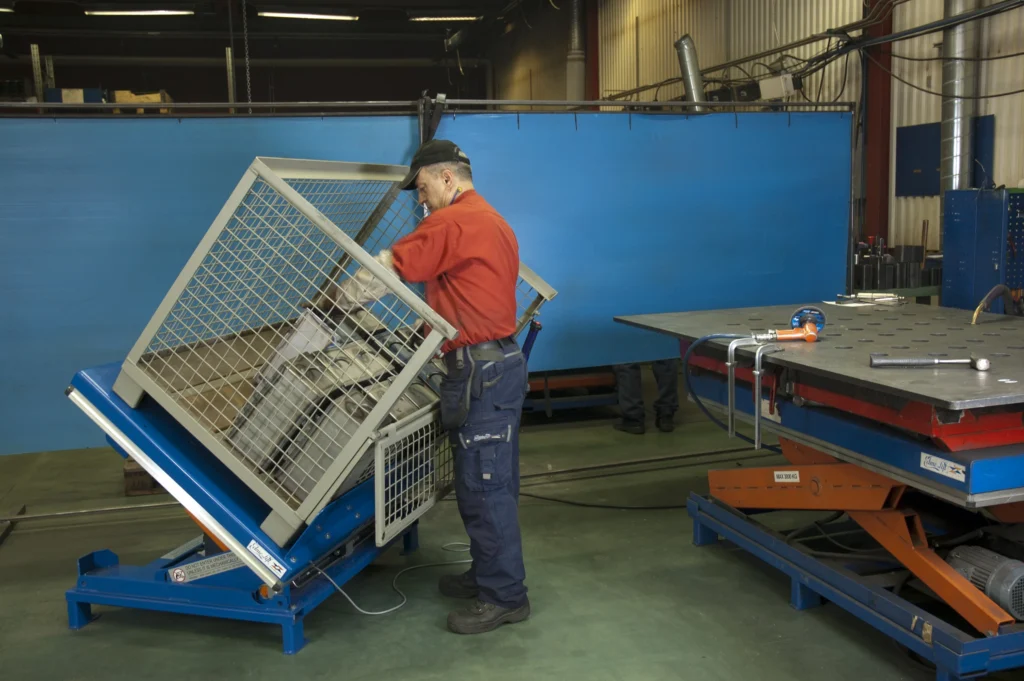 Operario utilizando una plataforma elevadora ergonómica para manipulación segura de cargas industriales.